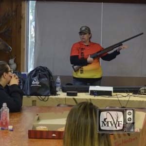 woman teaching firearm safety at hunter education course