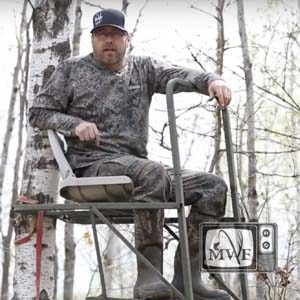 man facing camera sitting in tree stand